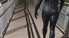 Tania in latex walks across the bridge