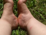 Gioco e simulo una sega coi piedi su un prato in pubblico