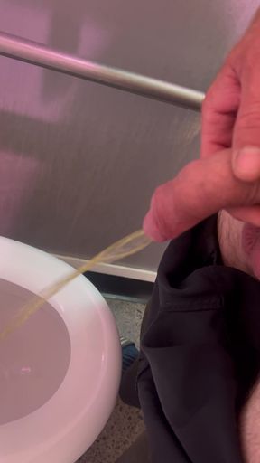 Pissing in a public toilet.