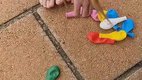 Carina playing with ballons and a compressor to burst them.