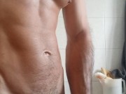 Muscular boy contracts muscles and penis in bathroom
