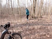 Early spring on bike pissing in the forest near the busy road