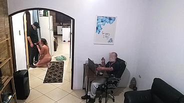 While the husband works, the wife in a towel greets the delivery man.