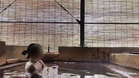 japanese girl bathing in a mixed outdoor bath at a hot spring inn