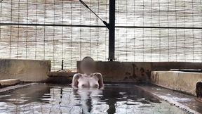 japanese girl bathing in a mixed outdoor bath at a hot spring inn