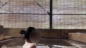 japanese girl bathing in a mixed outdoor bath at a hot spring inn