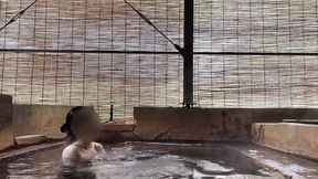 japanese girl bathing in a mixed outdoor bath at a hot spring inn