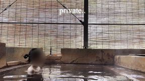 japanese girl bathing in a mixed outdoor bath at a hot spring inn