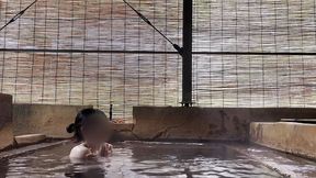 japanese girl bathing in a mixed outdoor bath at a hot spring inn