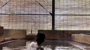 japanese girl bathing in a mixed outdoor bath at a hot spring inn