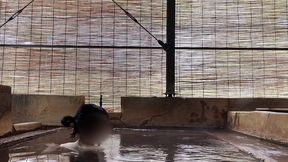 japanese girl bathing in a mixed outdoor bath at a hot spring inn