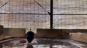 japanese girl bathing in a mixed outdoor bath at a hot spring inn