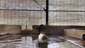 japanese girl bathing in a mixed outdoor bath at a hot spring inn