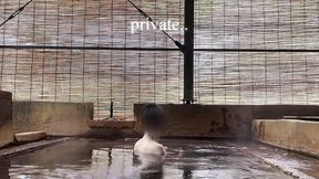 japanese girl bathing in a mixed outdoor bath at a hot spring inn