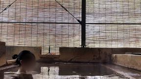 japanese girl bathing in a mixed outdoor bath at a hot spring inn