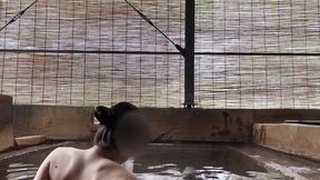 japanese girl bathing in a mixed outdoor bath at a hot spring inn