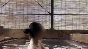 japanese girl bathing in a mixed outdoor bath at a hot spring inn