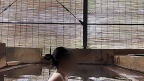 japanese girl bathing in a mixed outdoor bath at a hot spring inn