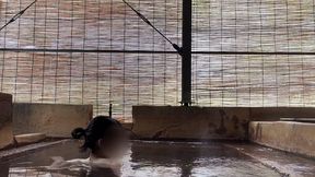 japanese girl bathing in a mixed outdoor bath at a hot spring inn