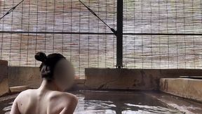 japanese girl bathing in a mixed outdoor bath at a hot spring inn