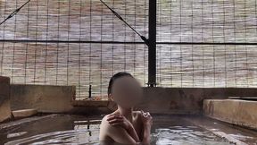 japanese girl bathing in a mixed outdoor bath at a hot spring inn