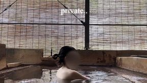 japanese girl bathing in a mixed outdoor bath at a hot spring inn