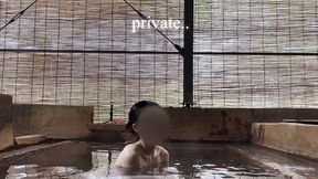 japanese girl bathing in a mixed outdoor bath at a hot spring inn