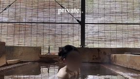 japanese girl bathing in a mixed outdoor bath at a hot spring inn