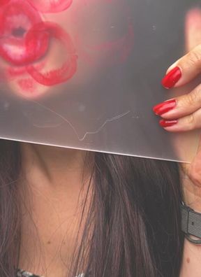 Reapplication of red lipstick. Kisses on plexiglass.