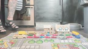 MissaRaeBerry toy car crush she cruses a small town with small cars buses and trucks in high heels close ground view