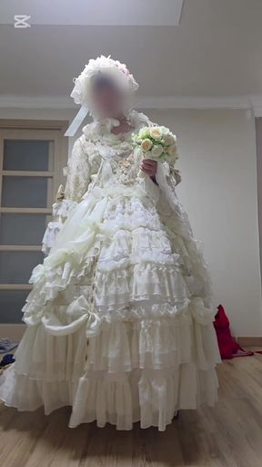 A man dressed as a woman in a wedding dress is being seductive.