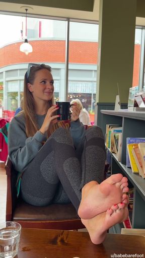 Cheeky girl shows off her feet at coffee shop