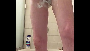 Skinny guy shaving in shower