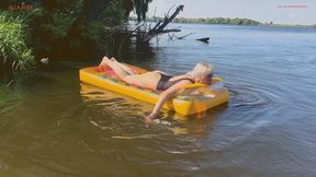 Floating and relaxing on a large and rare transparent inflatable mattress on the river