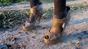 Broken high heels muddy and wet, bending high heels in mud, wrecked high heels, muddy shoes, girl in mud, barefoot in mud