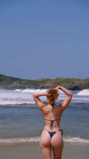 Busty redhead in a bikini shows off her big ass