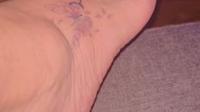 Magnifique pieds feet sensuel se caressant la cuisse avec ongles vernis rouge et tatouage