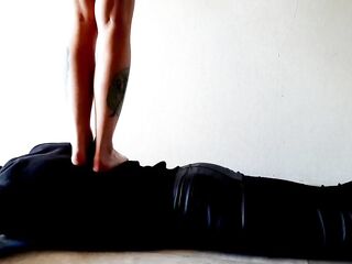 Trampling. Female-dominator Nika walks on the back of her thrall with in nature's garb feet