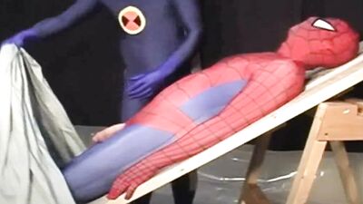 Kinky dude in a Spiderman outfit tied up and sucked off by another costumed homo