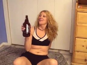 Blonde MILF rides a glass bottle with her pussy in bed