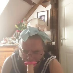 In a woman boy outfit with a mouth spreader to suck a dildo