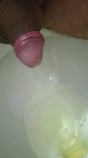 In the bathroom pissing