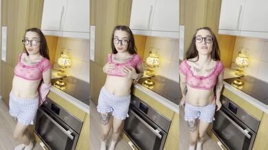 Slow striptease in the kitchen as tattooed glasses girl strips bare on the counter