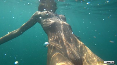 Nude model swims on a public beach in Russia.