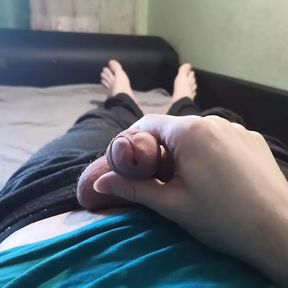 Guy in blue t-shirt jerking off his cock lying on the bed