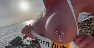 Boobs and pierced nipples playing on the beach