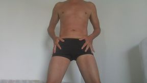 In swimming trunks and naked showing his body.