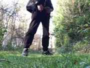 boy is urinating in the woods