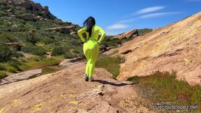 Luscious Lopez outdoors in neon jumpsuit