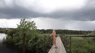 Naked girl walks on the bridge